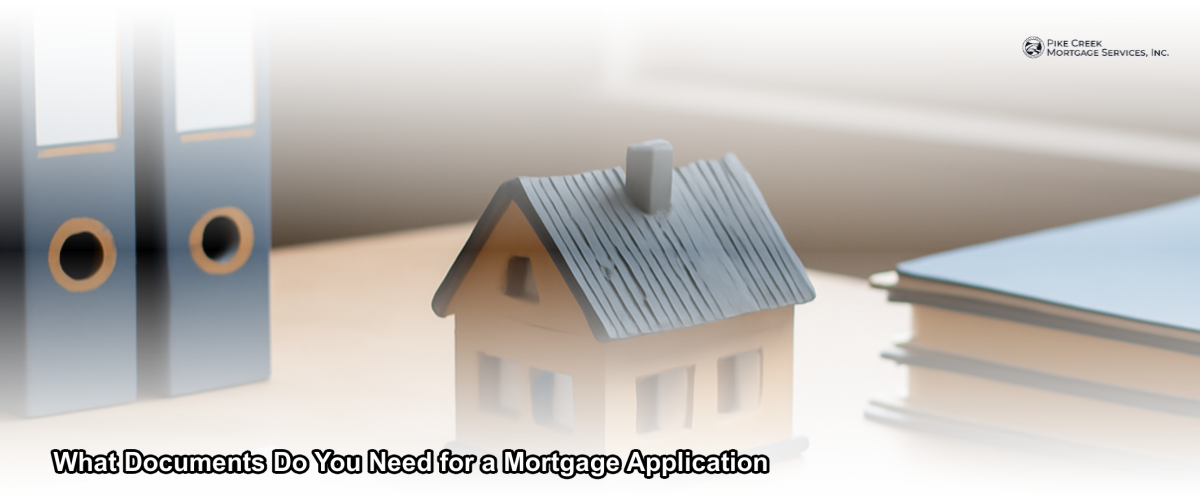 A neatly organized stack of mortgage application documents on a desk with a pen and a home in the background