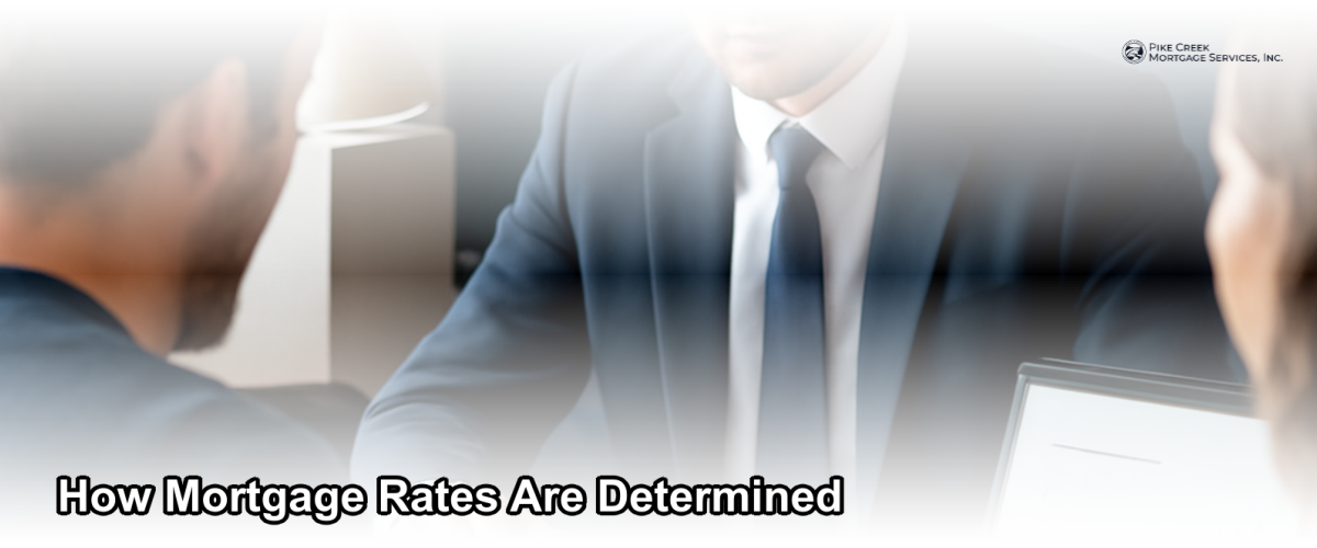 A mortgage loan officer reviewing interest rate charts with a homebuyer at a desk in a bright professional office setting