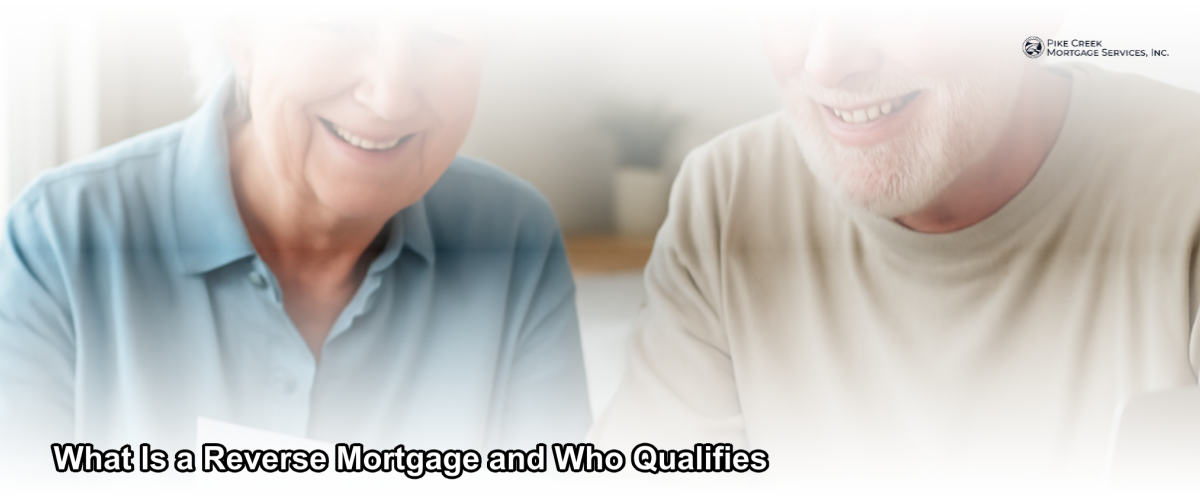A smiling older couple reviewing mortgage documents at a kitchen table in their Newark Delaware home