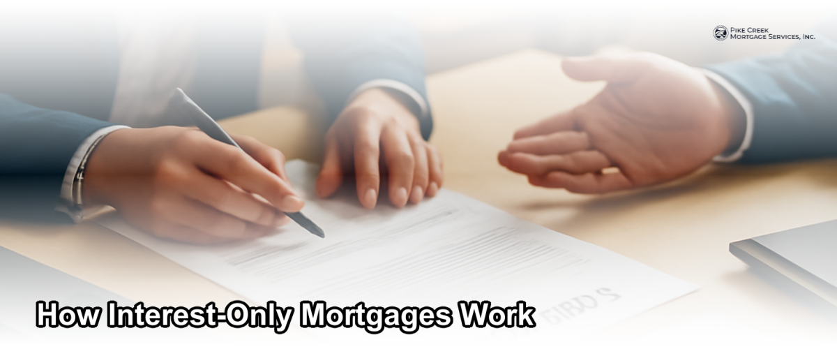 A financial advisor reviewing mortgage documents with a homebuyer at a desk, representing interest-only mortgage planning in Newark, Delaware.