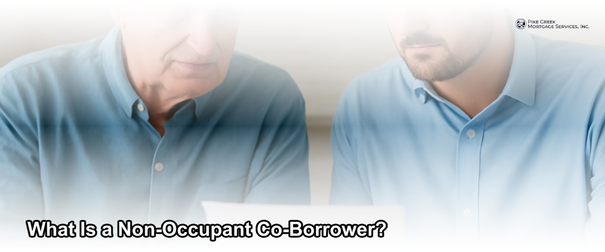 Two people reviewing mortgage documents together at a kitchen table, representing a co-borrower arrangement for a home loan